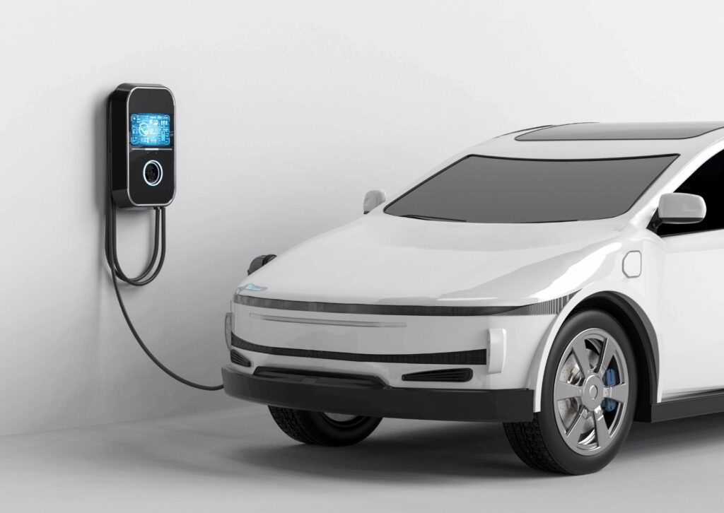 White electric car charging at a wall station, highlighting EV specific tire replacement and modern EV maintenance.