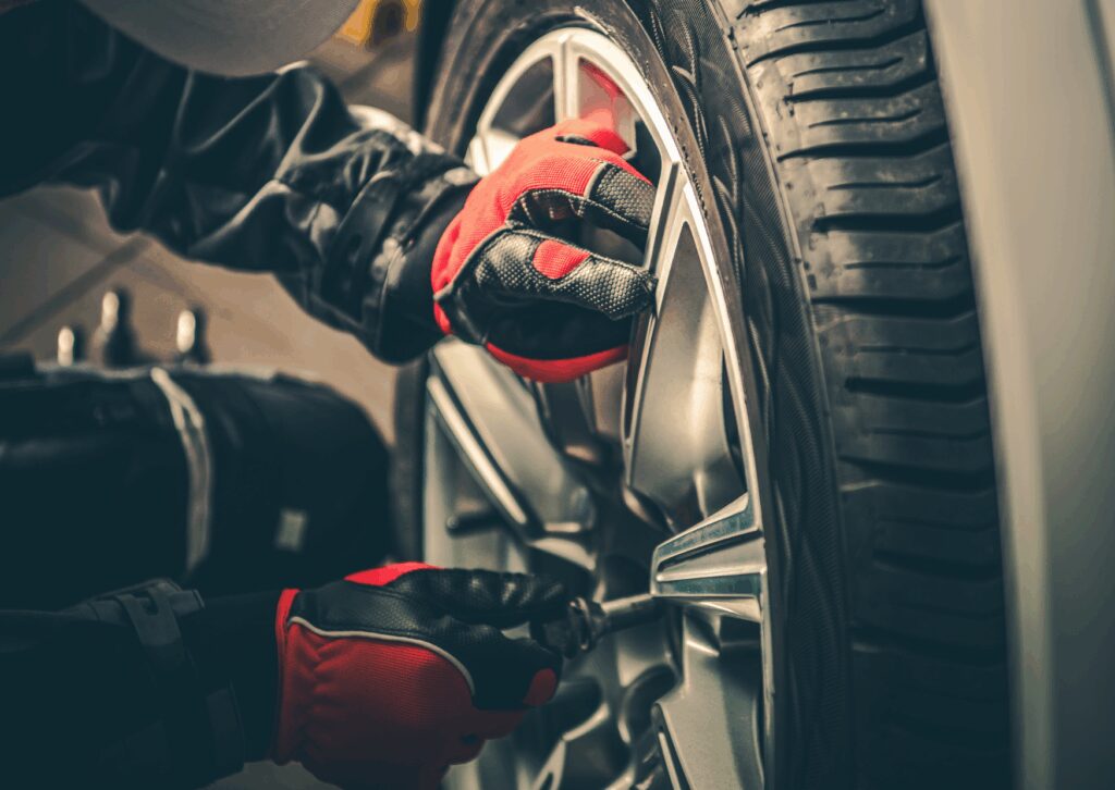 Row of new car tires mounted on silver alloy wheels, close-up view highlighting tread detail and smooth rim surfaces.