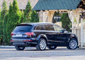 Black Audi Q7 parked outdoors, showing the rear profile, wheels, taillights, and SUV body design