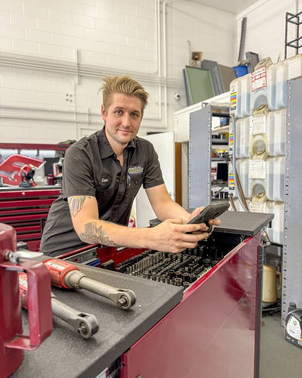 Metric Motors technician at his toolbox with a tablet