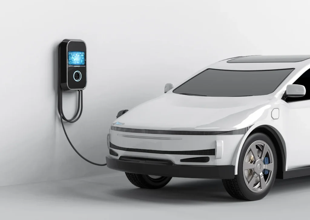 White electric SUV plugged into wall-mounted charger in minimalist garage, cable connected to front port.