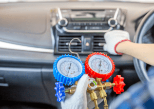 Technician testing dashboard vents with gauges for car ac and climate control repair service 